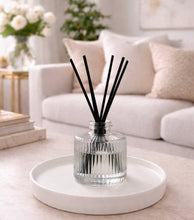 Daisy Blue Home Fragrance Rivelle Reed Diffuser Bottle with wooden reeds and decorative glass container for home fragrance.