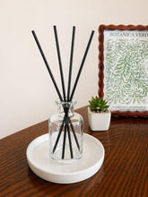 Daisy Blue Home Fragrance Mirelle reed diffuser bottle with elegant glass design and natural reed sticks for home scenting.